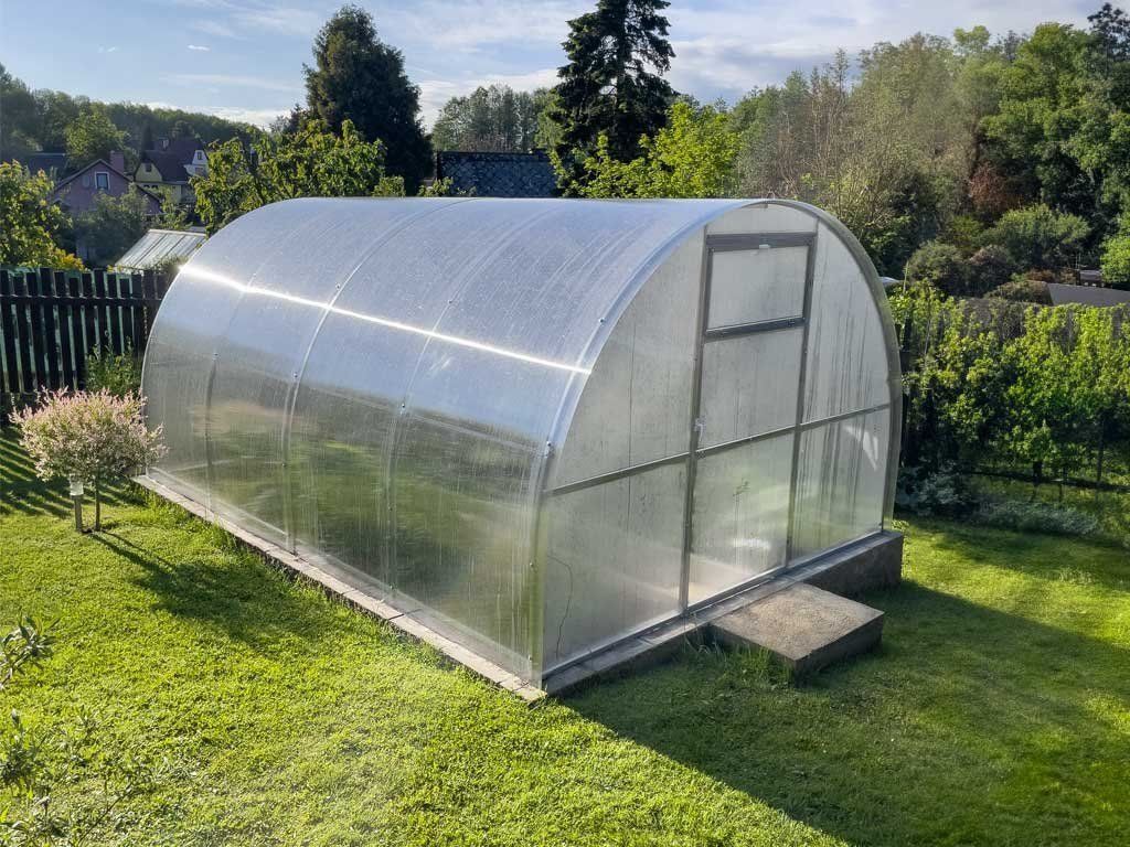 Zahradní skleník LEGI OREGANO 4 × 3 m 6 mm — obloukový skleník z pozinkované oceli v zahradě